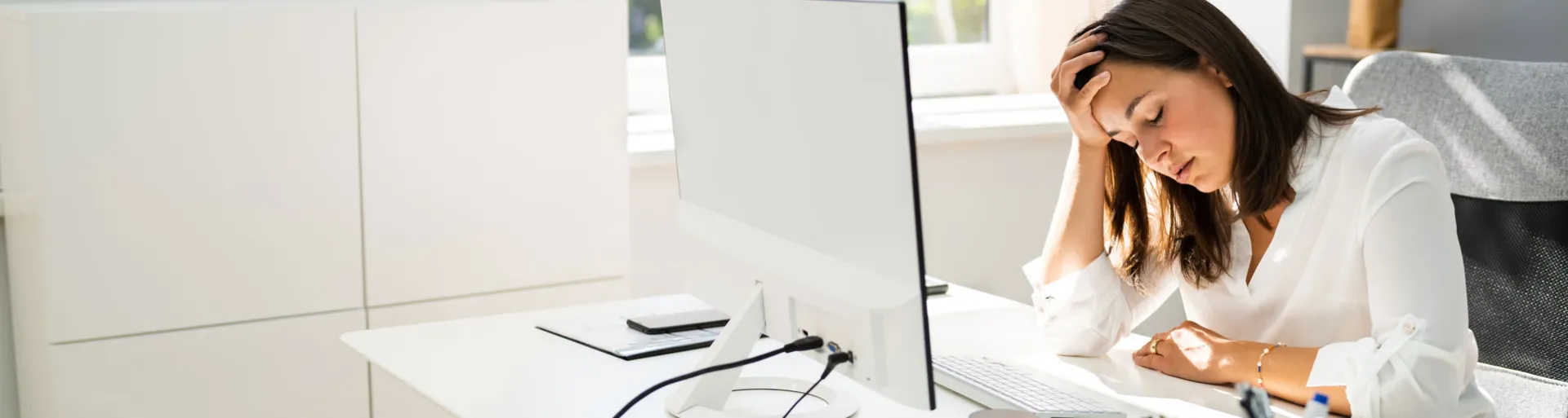 vrouw gestrest achter haar computer op het werk